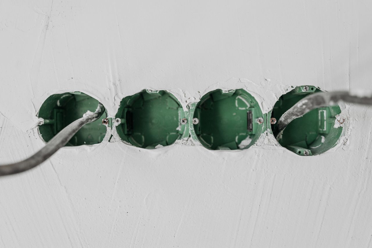 Mastering the First Impression: Your intriguing post title goes here Close-up of green electrical boxes and wiring in a wall setup.