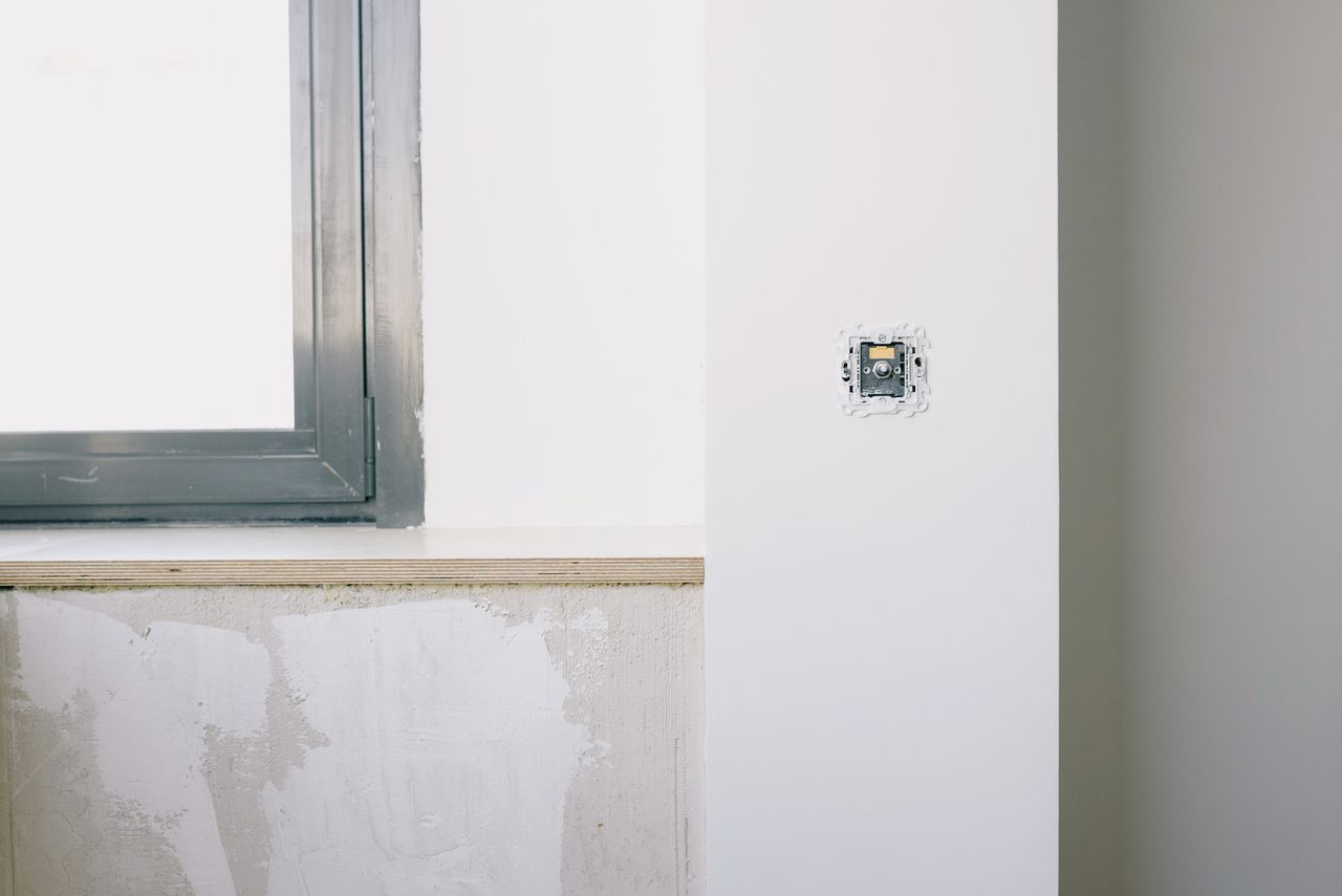 Crafting Captivating Headlines: Your awesome post title goes here Repairs and installation of new electrical outlet on white wall near window in light apartment